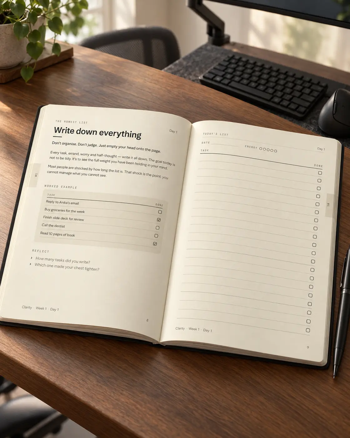 Open Clarity planner showing the Day 1 guidance and blank writing page on a warm wooden desk